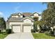 Charming two-story home featuring a two-car garage, a well-manicured lawn, and a welcoming light blue front door at 2624 Daulby St, Kissimmee, FL 34747