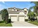 Well-maintained two-story home featuring a two-car garage, manicured lawn and tropical landscaping at 2624 Daulby St, Kissimmee, FL 34747