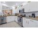 Bright kitchen with white cabinets, granite countertops, stainless steel appliances, and modern tile flooring and backsplash at 2624 Daulby St, Kissimmee, FL 34747