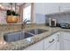 Beautifully appointed kitchen area with stainless steel sink and complementary granite countertops at 2624 Daulby St, Kissimmee, FL 34747