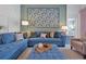 Comfortable living room with blue sectional sofa, patterned ottoman, and neutral armchairs at 2624 Daulby St, Kissimmee, FL 34747