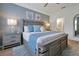 Calming main bedroom featuring a serene blue color scheme, a ceiling fan, and views into the ensuite bathroom at 2624 Daulby St, Kissimmee, FL 34747