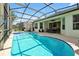 Beautiful backyard pool with a screened-in enclosure, an outdoor dining area, and space for lounging at 2624 Daulby St, Kissimmee, FL 34747