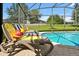 Inviting pool area with lounge chairs, sunbathing towels, and a screened-in enclosure offering a serene outdoor retreat at 2624 Daulby St, Kissimmee, FL 34747