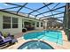 Relaxing screened-in pool area featuring a jacuzzi, lounge chairs, and outdoor dining space perfect for entertaining at 2624 Daulby St, Kissimmee, FL 34747