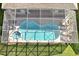Aerial view of a screened-in pool and jacuzzi with patio seating and a well-maintained lawn at 2624 Daulby St, Kissimmee, FL 34747