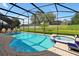 Relaxing screened-in pool and jacuzzi with ample lounge chairs and a beautiful green lawn perfect for outdoor enjoyment at 2624 Daulby St, Kissimmee, FL 34747