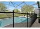 View of pool with safety fence and screened-in enclosure at 2624 Daulby St, Kissimmee, FL 34747