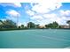Outdoor tennis court surrounded by lush landscaping and clear skies for recreational play at 2624 Daulby St, Kissimmee, FL 34747