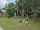 Exterior view with large picture windows on one side surrounded by overgrown greenery at 2638 S Laurel Ave, Sanford, FL 32773