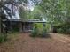 Modest single story home with brick facade partially obscured by overgrown landscaping in the front yard at 2638 S Laurel Ave, Sanford, FL 32773