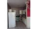 Compact kitchen equipped with white cabinetry, stainless steel appliances, and tiled flooring at 2638 S Laurel Ave, Sanford, FL 32773
