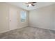 Bright bedroom featuring neutral walls, gray carpet, and a ceiling fan at 2932 Muller Oak Loop, Ocoee, FL 34761