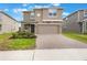 Charming two-story home featuring a two-car garage, neutral stucco exterior, and a neatly paved driveway at 2932 Muller Oak Loop, Ocoee, FL 34761