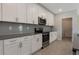Well-appointed kitchen featuring white cabinets, stainless steel appliances, and a sleek gray backsplash at 2932 Muller Oak Loop, Ocoee, FL 34761