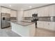 Bright kitchen showcasing an island sink, stainless steel refrigerator, and ample countertop space at 2932 Muller Oak Loop, Ocoee, FL 34761