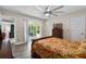 Bedroom with gray wood floors, ceiling fan, and backyard pool access at 3606 Palm Ave, Apopka, FL 32703