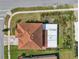 An aerial view of a home with an orange tile roof surrounded by beautifully landscaped lawns and garden beds at 3966 Steer Beach Pl, Kissimmee, FL 34746