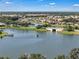 Picturesque aerial of lakefront homes with a bridge, boat and lush landscaping in a desirable community at 3966 Steer Beach Pl, Kissimmee, FL 34746