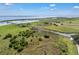 Expansive aerial view showcasing a community pier and lake with picturesque green surroundings under a blue sky at 3966 Steer Beach Pl, Kissimmee, FL 34746
