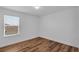 A cozy bedroom with wood-look floors and a bright window at 3966 Steer Beach Pl, Kissimmee, FL 34746