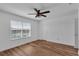 Bright bedroom with wood-look floors, a ceiling fan, and a window with blinds at 3966 Steer Beach Pl, Kissimmee, FL 34746
