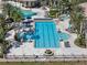 Aerial view of a sparkling community pool area with lounge chairs, palm trees, and well-manicured landscaping at 3966 Steer Beach Pl, Kissimmee, FL 34746