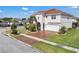 Beautiful two-story home with a terracotta roof, a brick driveway, manicured landscaping, and a two-car garage at 3966 Steer Beach Pl, Kissimmee, FL 34746