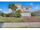 Beautiful two-story home with a well-manicured lawn and brick driveway at 3966 Steer Beach Pl, Kissimmee, FL 34746