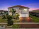 Elegant two-story home with well-maintained landscaping, a terracotta roof, brick driveway, and attached two-car garage at 3966 Steer Beach Pl, Kissimmee, FL 34746