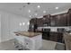 Modern kitchen featuring a granite island with seating and dark wood cabinets at 3966 Steer Beach Pl, Kissimmee, FL 34746