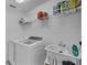 Well-lit laundry room equipped with a washer, dryer, sink, and ample shelving for storage at 3966 Steer Beach Pl, Kissimmee, FL 34746
