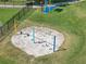 Aerial view of a community playground with colorful swing sets and a soft sandy base for safe play at 3966 Steer Beach Pl, Kissimmee, FL 34746