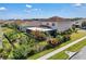 The rear exterior of this home features a terra cotta roof, screened lanai, and meticulously landscaped fenced yard at 3966 Steer Beach Pl, Kissimmee, FL 34746