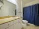 Well-lit bathroom with vanity, granite countertops, and a shower-tub combination with a blue curtain at 430 Southern Pecan Cir # 101, Winter Garden, FL 34787