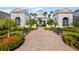Inviting clubhouse entrance with brick walkway, benches, colorful flowers, and manicured landscaping at 430 Southern Pecan Cir # 101, Winter Garden, FL 34787