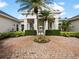 Clubhouse entrance with a circular brick driveway, lush greenery, and well-maintained landscaping at 430 Southern Pecan Cir # 101, Winter Garden, FL 34787