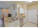 Galley kitchen with white cabinets, stone countertops, and stainless steel appliances at 430 Southern Pecan Cir # 101, Winter Garden, FL 34787