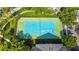 Aerial view of a fenced tennis court, surrounded by lush trees and greenery, offering a private recreational space at 430 Southern Pecan Cir # 101, Winter Garden, FL 34787