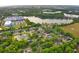 Beautiful aerial view of a residential neighborhood featuring lush greenery, a lake, and nearby commercial buildings at 4448 Riverton Dr, Orlando, FL 32817