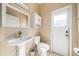 Well-lit bathroom features a pedestal sink, updated toilet, and tiled floors at 4448 Riverton Dr, Orlando, FL 32817
