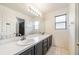 Bathroom features a large mirror, double sinks, updated fixtures, and tile flooring at 4448 Riverton Dr, Orlando, FL 32817