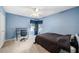 A well-lit bedroom featuring a ceiling fan, carpet, and an adjacent desk for work or study at 4448 Riverton Dr, Orlando, FL 32817