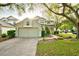 Two-story home featuring a well-manicured lawn, rock garden, and a convenient two-car garage at 4448 Riverton Dr, Orlando, FL 32817