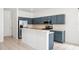 Well-lit kitchen features stainless steel appliances, white countertops, and modern blue cabinets at 4448 Riverton Dr, Orlando, FL 32817