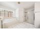 Main bath featuring a soaking tub, glass shower, and natural lighting at 4448 Riverton Dr, Orlando, FL 32817