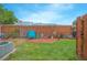 Fenced backyard featuring a small garden area, grass, and a blue lawn chair at 4541 Southfield Ave, Orlando, FL 32812
