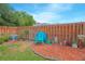 Fenced backyard featuring a small garden area, grass, and a blue lawn chair at 4541 Southfield Ave, Orlando, FL 32812