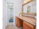 Bright bathroom with a vanity, framed mirror, and a view into an additional bathroom area at 4541 Southfield Ave, Orlando, FL 32812