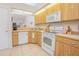 Traditional kitchen featuring wood-grain cabinets, white appliances, and plenty of counter space at 4541 Southfield Ave, Orlando, FL 32812